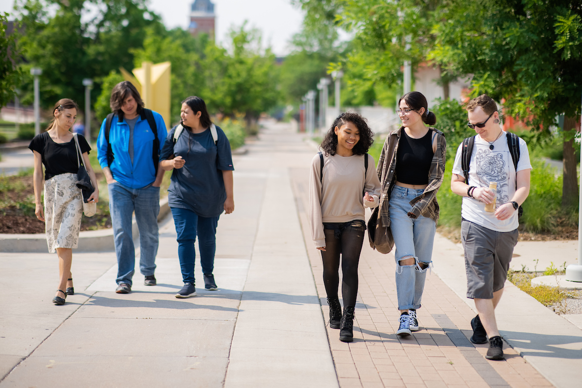 Two groups of students walking on campus